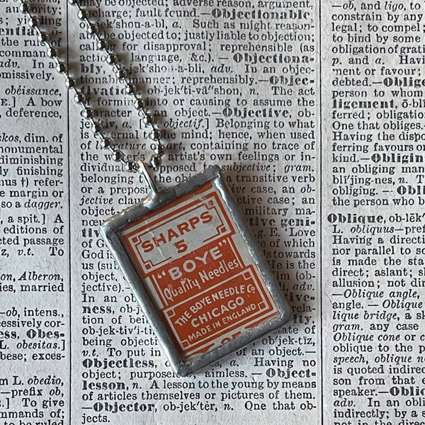 Sewing needle vintage packaging typography,  upcycled to soldered glass pendant