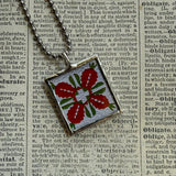 Antique quilt with flower designs, upcycled to hand-soldered glass pendant