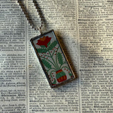 Antique quilt with flower designs, upcycled to hand-soldered glass pendant