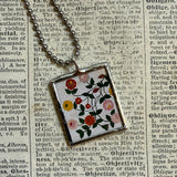 Antique quilt with flower designs, upcycled to hand-soldered glass pendant