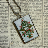 Antique quilt with flower designs, upcycled to hand-soldered glass pendant