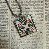 Antique quilt with flower designs, upcycled to hand-soldered glass pendant